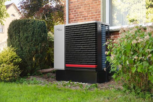 Installateur plaatst een hybride warmtepomp bij een Nederlandse eengezinswoning