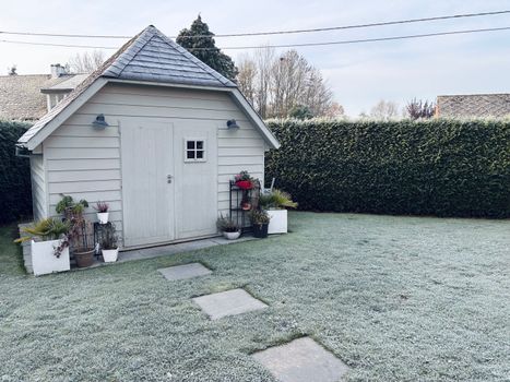Kleine Nederlandse stadstuin die winterklaar wordt gemaakt met bladeren opruimen, potten beschermen en meubels opbergen